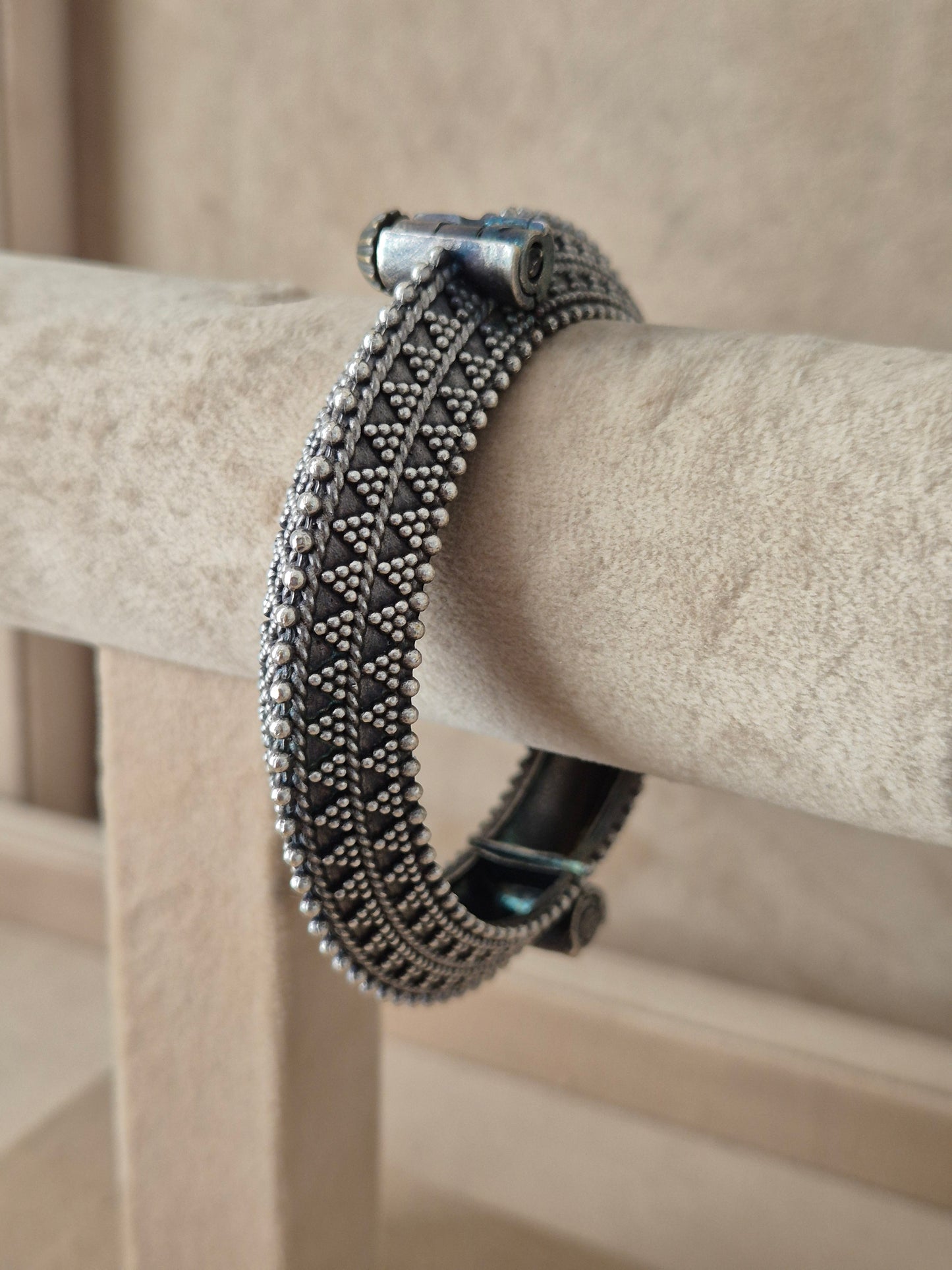 Detailed antique silver oxidized bangle with a textured geometric pattern by naitri.in