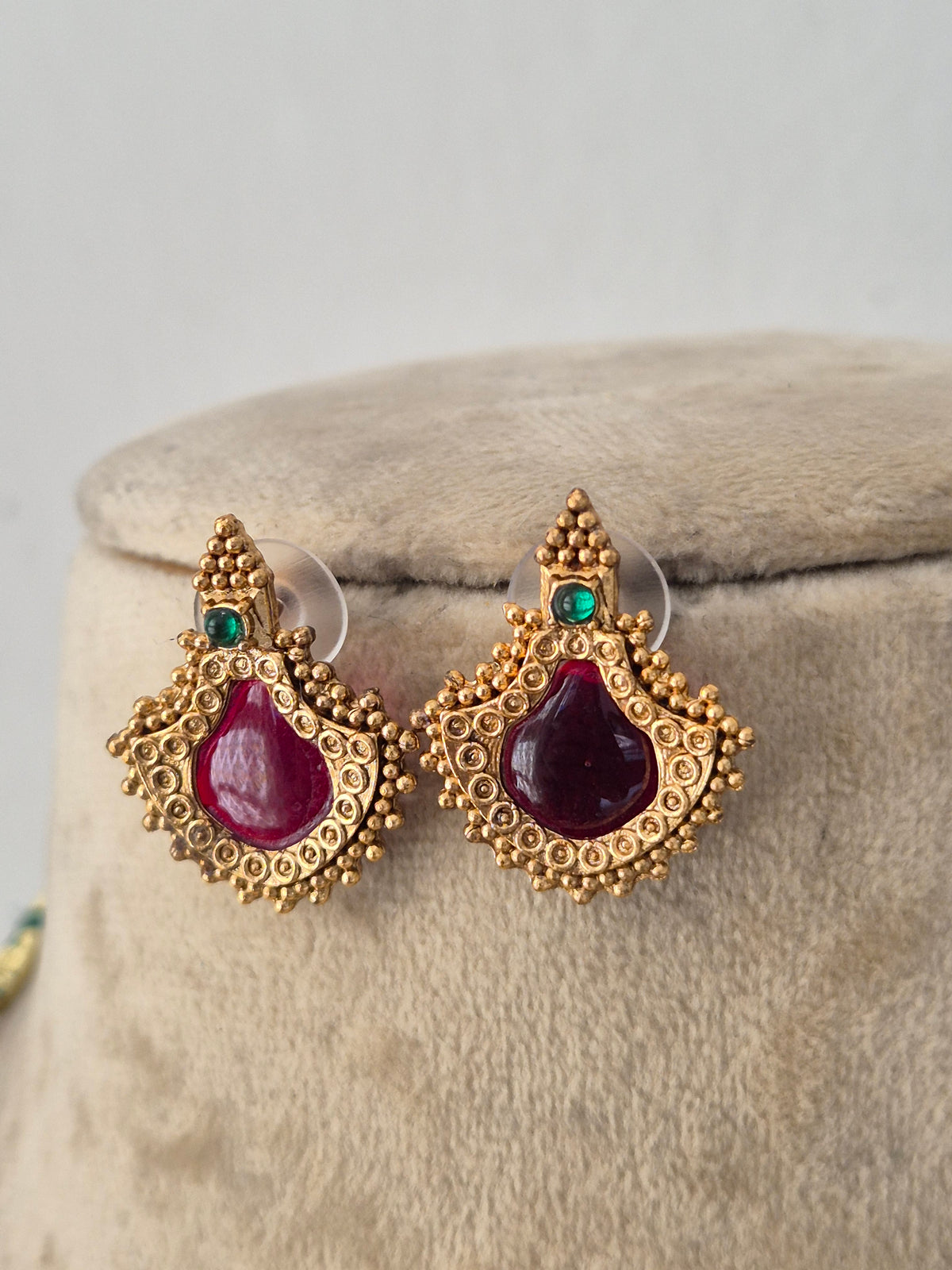 Gold-toned ethnic earring set with red and green stone accents by Naitri.in
