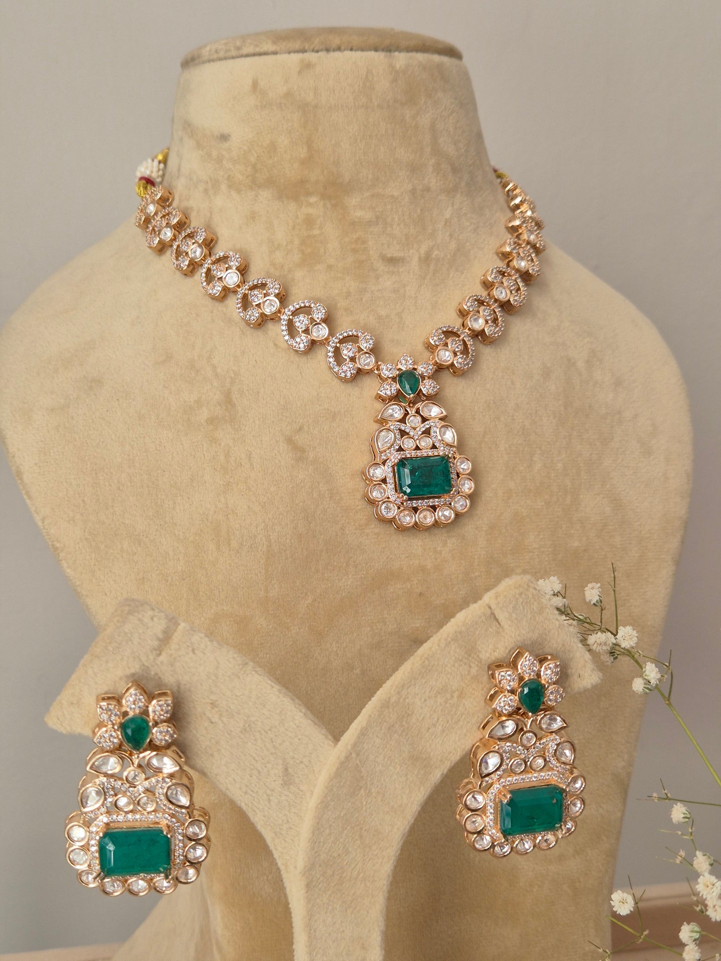Close-up of a handcrafted jewelry set with intricate crystal clusters and vibrant green focal stones by naitri.in