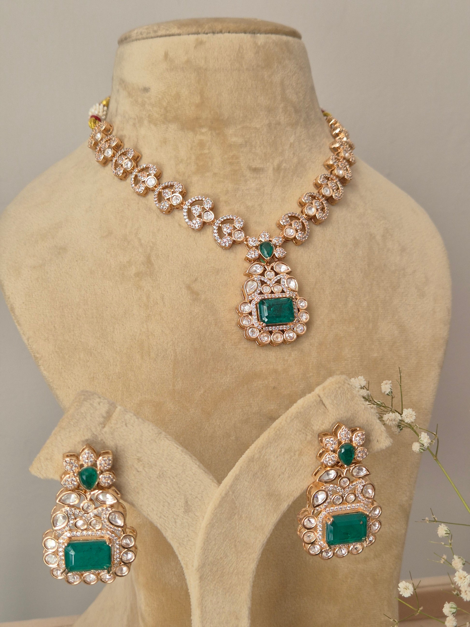 Close-up of a handcrafted jewelry set with intricate crystal clusters and vibrant green focal stones by naitri.in