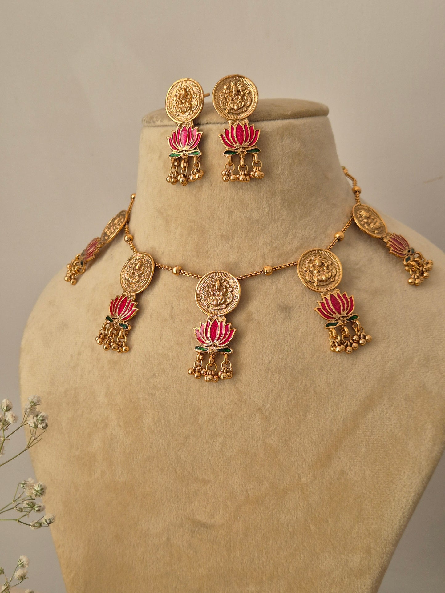Handcrafted brass alloy jewelry set with traditional coin-style motifs, pink enamel lotus charms, and small Jhumka drops by naitri.in