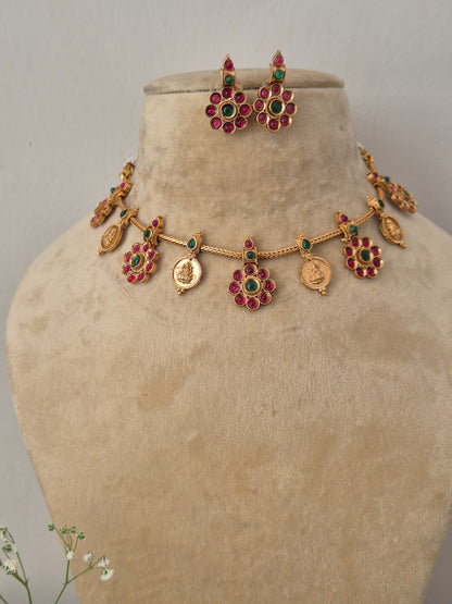 Modern Indian ethnic imitation jewelry set including a textured golden brass alloy choker necklace with vibrant ruby-red and emerald-green stone accents, by  naitri.in