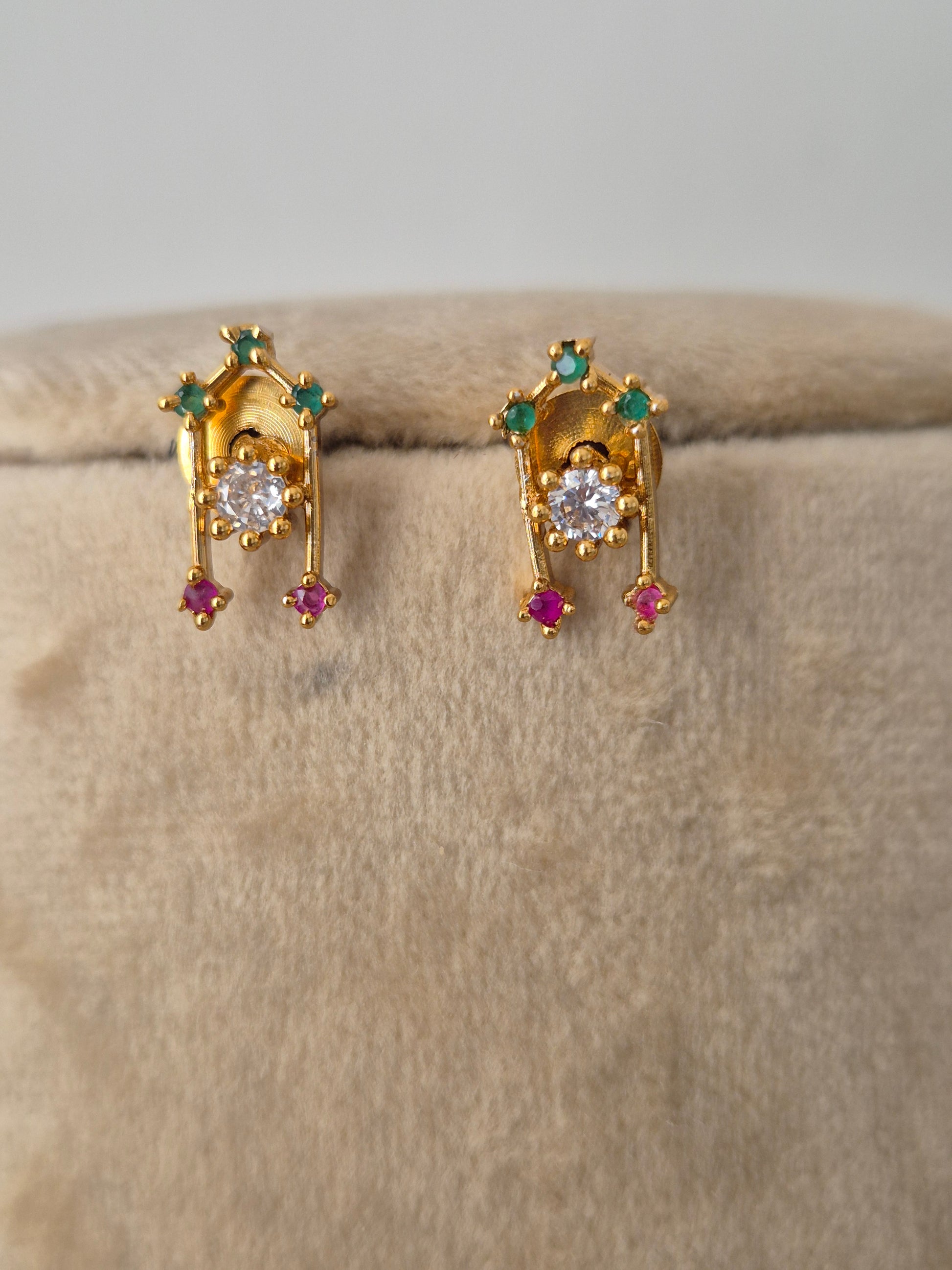 Minimalist gold-toned earring  with dangling teardrop motifs in vibrant pinkish-red and sparkling clear crystals, by naitri.in