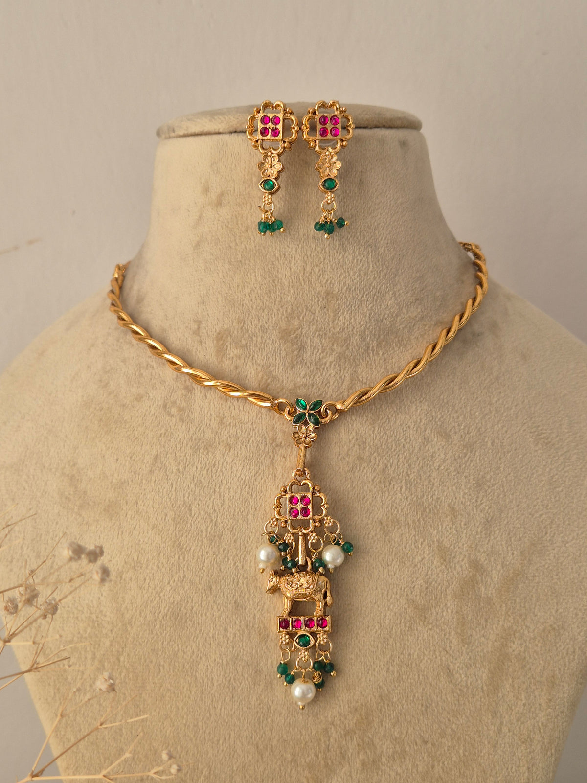 Handcrafted Brass Alloy Ethnic Necklace with a detailed vertical pendant design, featuring subtle gemstone insets and graceful pearl drops styled against a clean by Naitri.in