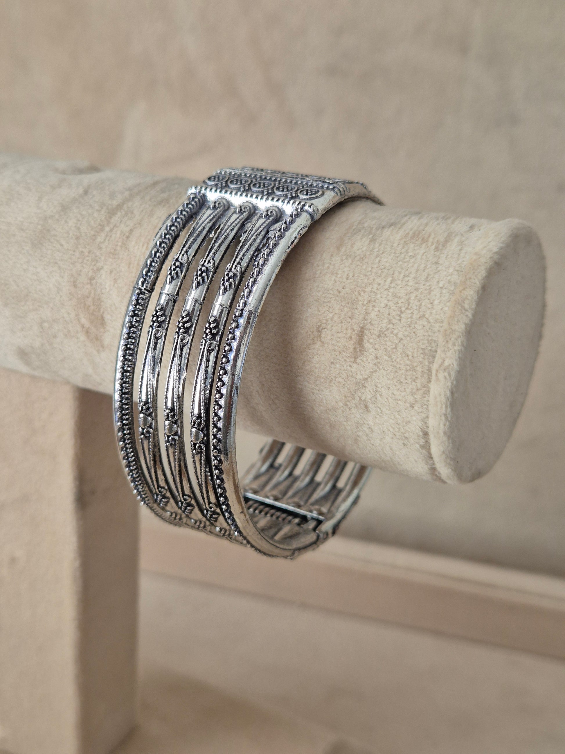 Bohemian-style wide silver-plated statement cuff bracelet featuring vertical geometric lines and intricate metallic patterns by naitri.in