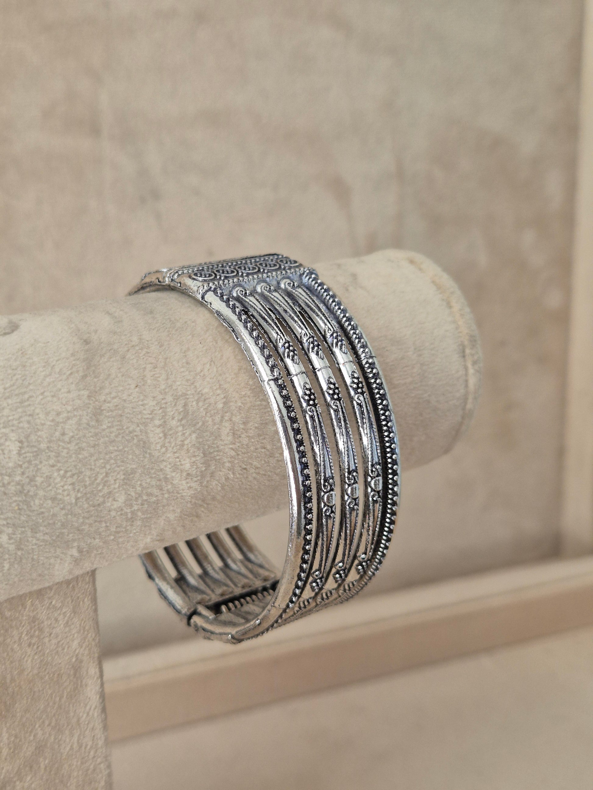 Wide oxidized silver Basanti cuff bangle with vertical cutout panels and geometric engravings  by naitri.in