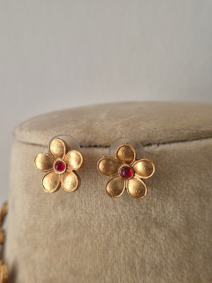 Gold-plated floral earrngs with delicate floral motifs and pinkish-red stone centers, by naitri.in