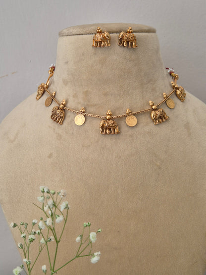 Fine craftsmanship golden ethnic necklace set with intricate dangling design elements Traditional gold-toned choker necklace  with hanging coin motifs and matching earrings by naitri.in
