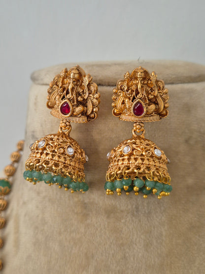 Gold-plated temple jewelry earring with a Lord Ganesha pendant, green gemstone beads, and matching jhumka earrings by naitri.in