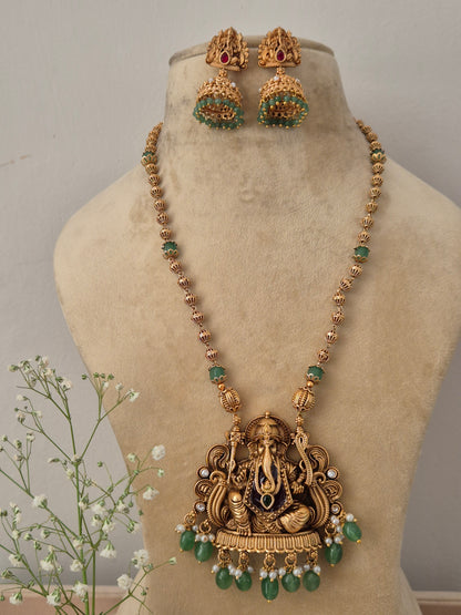 Gold-plated temple jewelry necklace with a Lord Ganesha pendant, green gemstone beads, and matching jhumka by naitri.in