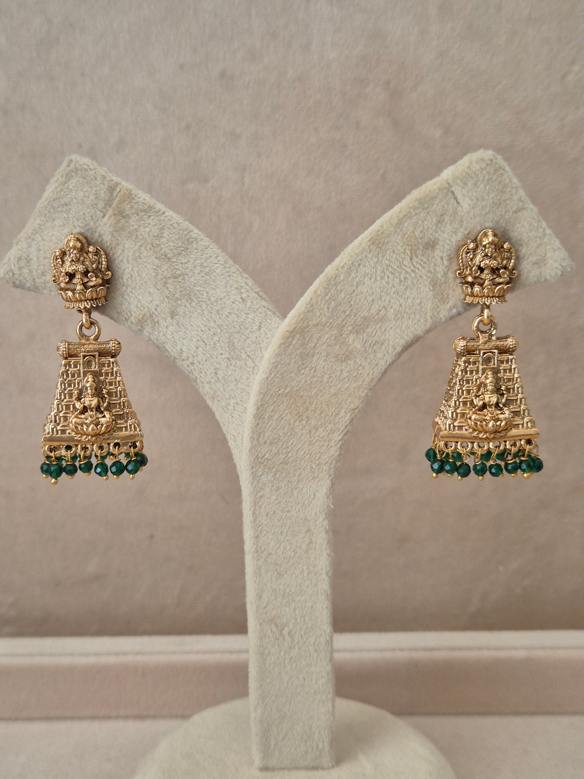 Traditional gold-plated Bhumika Jhumka earrings with a Goddess motif and dangling green beads by naitri.in