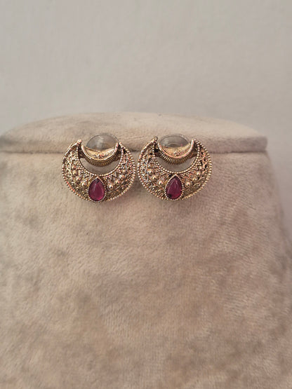 Delicate gold crescent-shaped earrings with red stone accents by naitri.in