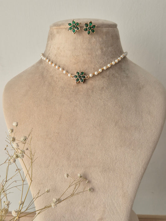 Pearl choker necklace with a green stone floral pendant and matching stud earrings by naitri.in