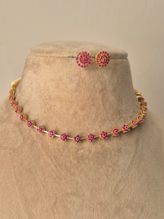 Close-up of the Chameli Necklace Set, a handcrafted brass alloy jewelry set with a polished golden finish and small pink circular gemstones by naitri.in