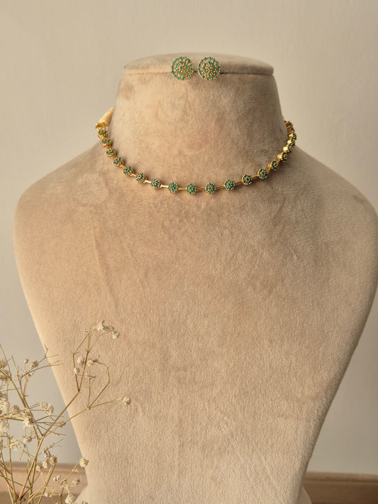 Champa Necklace Set featuring a minimal gold-plated chain with green American Diamond accents and matching floral stud earrings by naitri.in