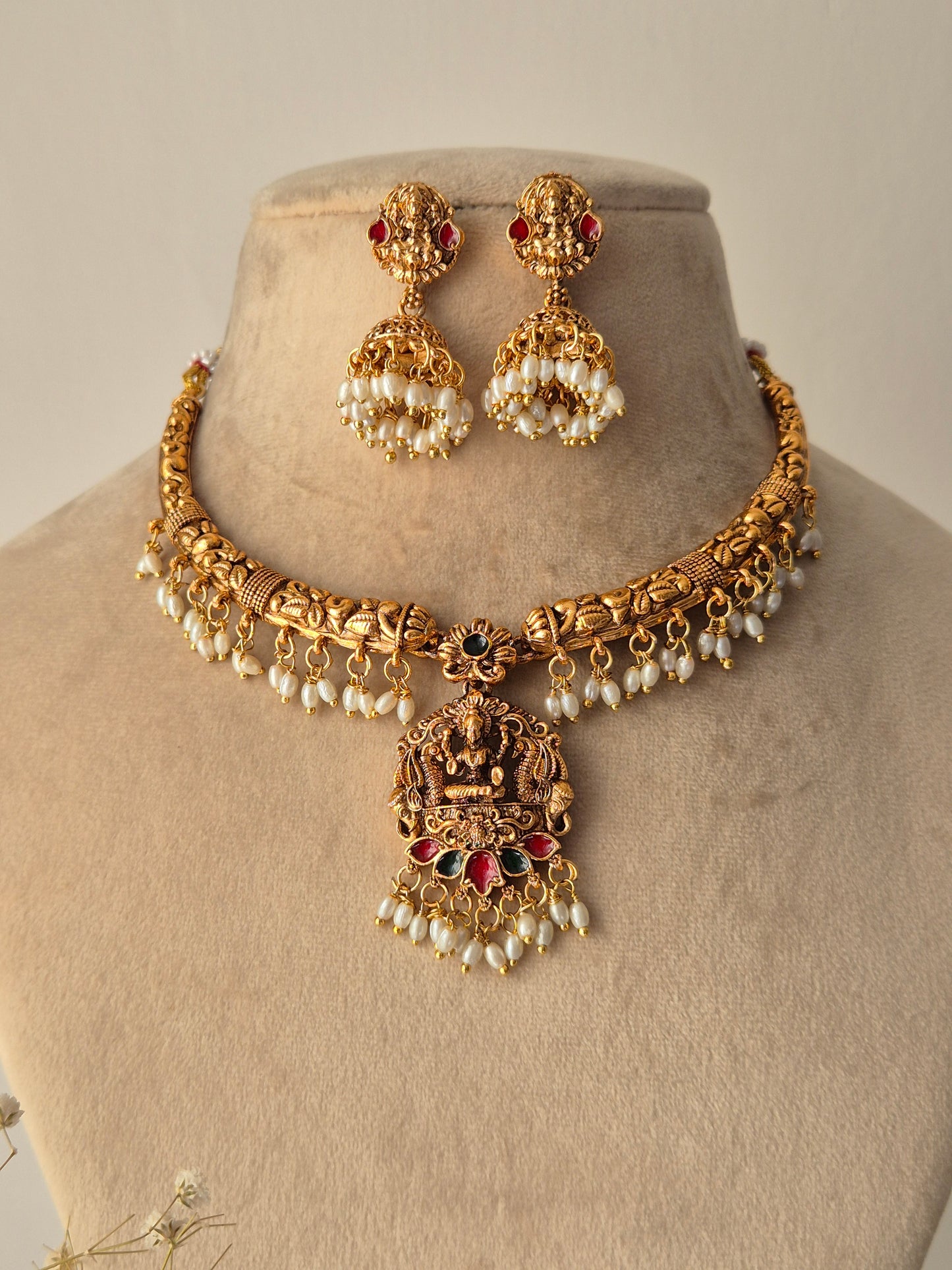 Handcrafted Masterpiece with lots  Detailing golden necklace and goddess motifs earrings with green-red stones small pearls hanging attached with necklace and jhumkas by naitri.in
