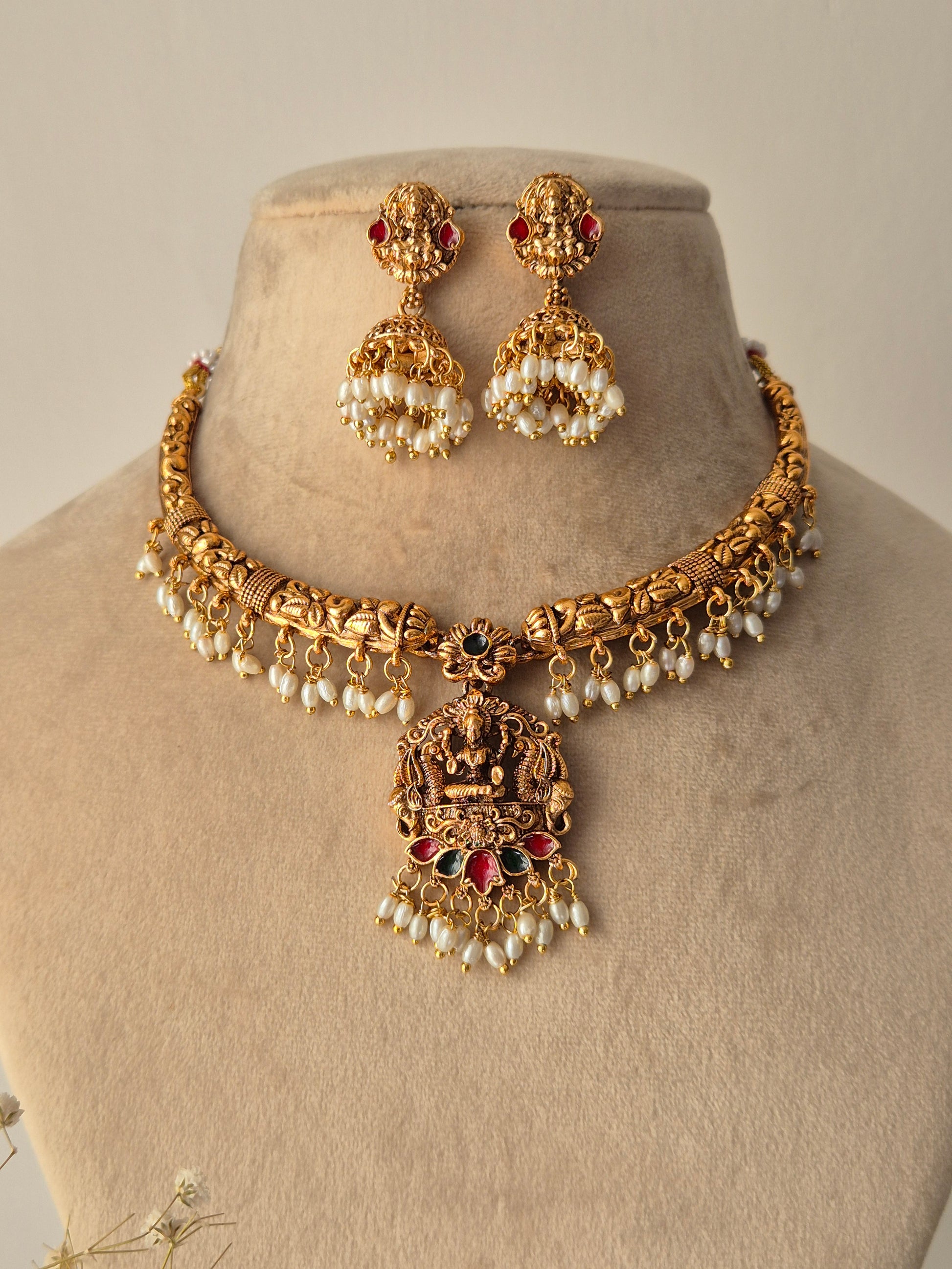 Handcrafted Masterpiece with lots  Detailing golden necklace and goddess motifs earrings with green-red stones small pearls hanging attached with necklace and jhumkas by naitri.in