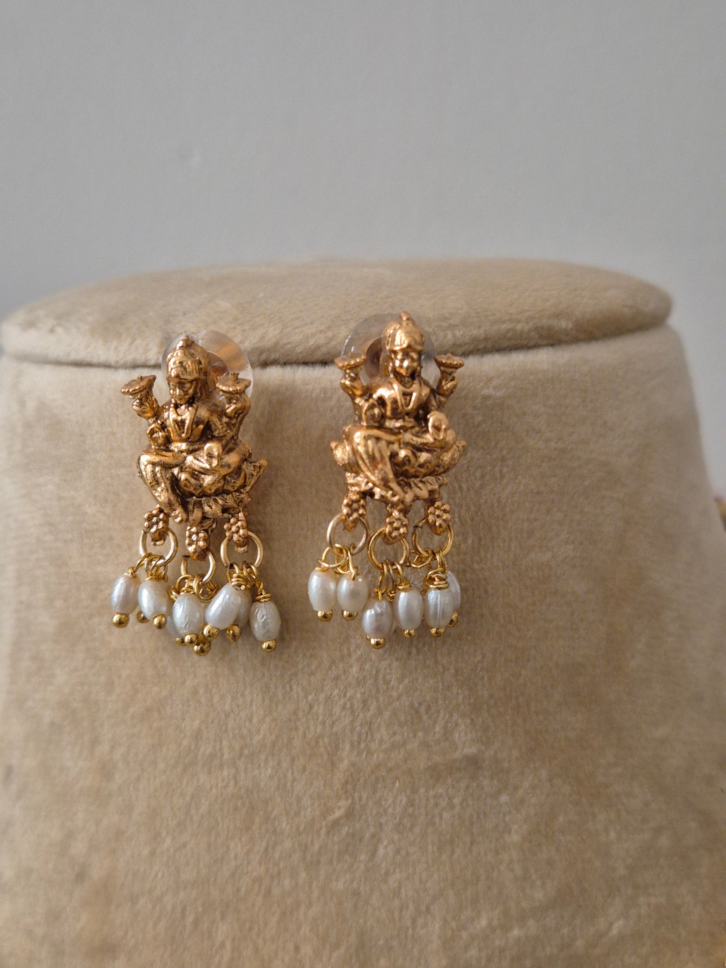 Goddess Lakshmi central motif, intricate floral carvings, and delicate white pearl droplets earring by naitri.in