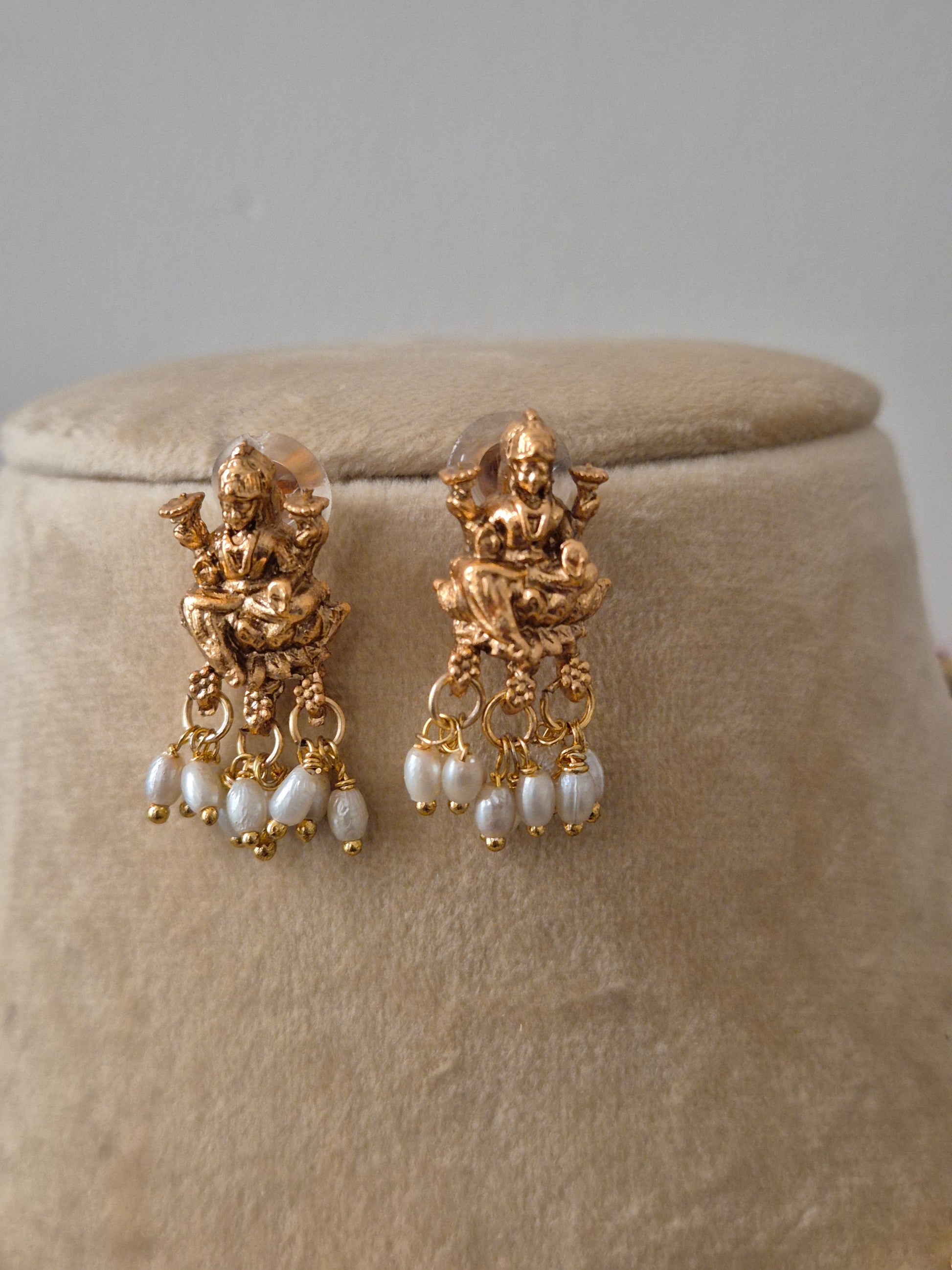 Goddess Lakshmi central motif, intricate floral carvings, and delicate white pearl droplets earring by naitri.in