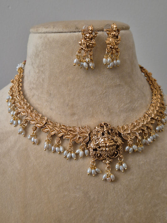 Traditional gold-toned Lakshmi choker necklace and earring set with pearl hangings by naitri.in