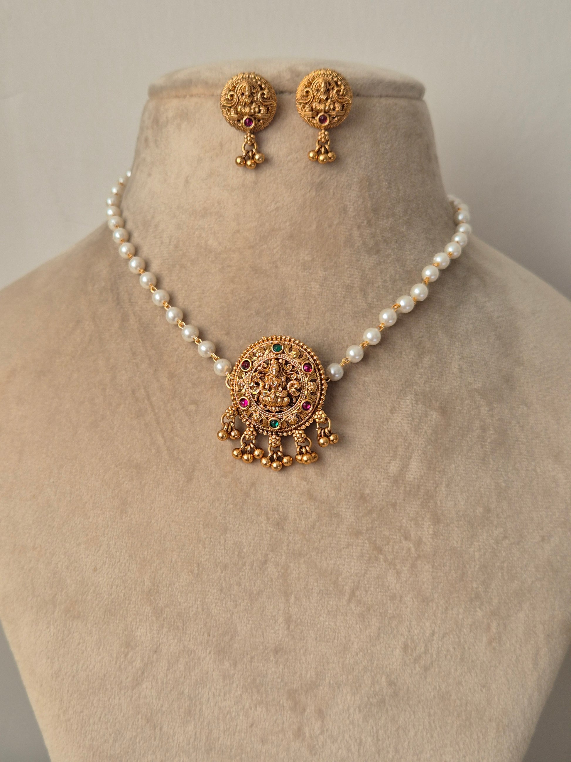 Goddess Lakshmi motif choker set with red and green kemp stones, intricate Nakshi carvings, and matching jhumka earrings by naitri.in