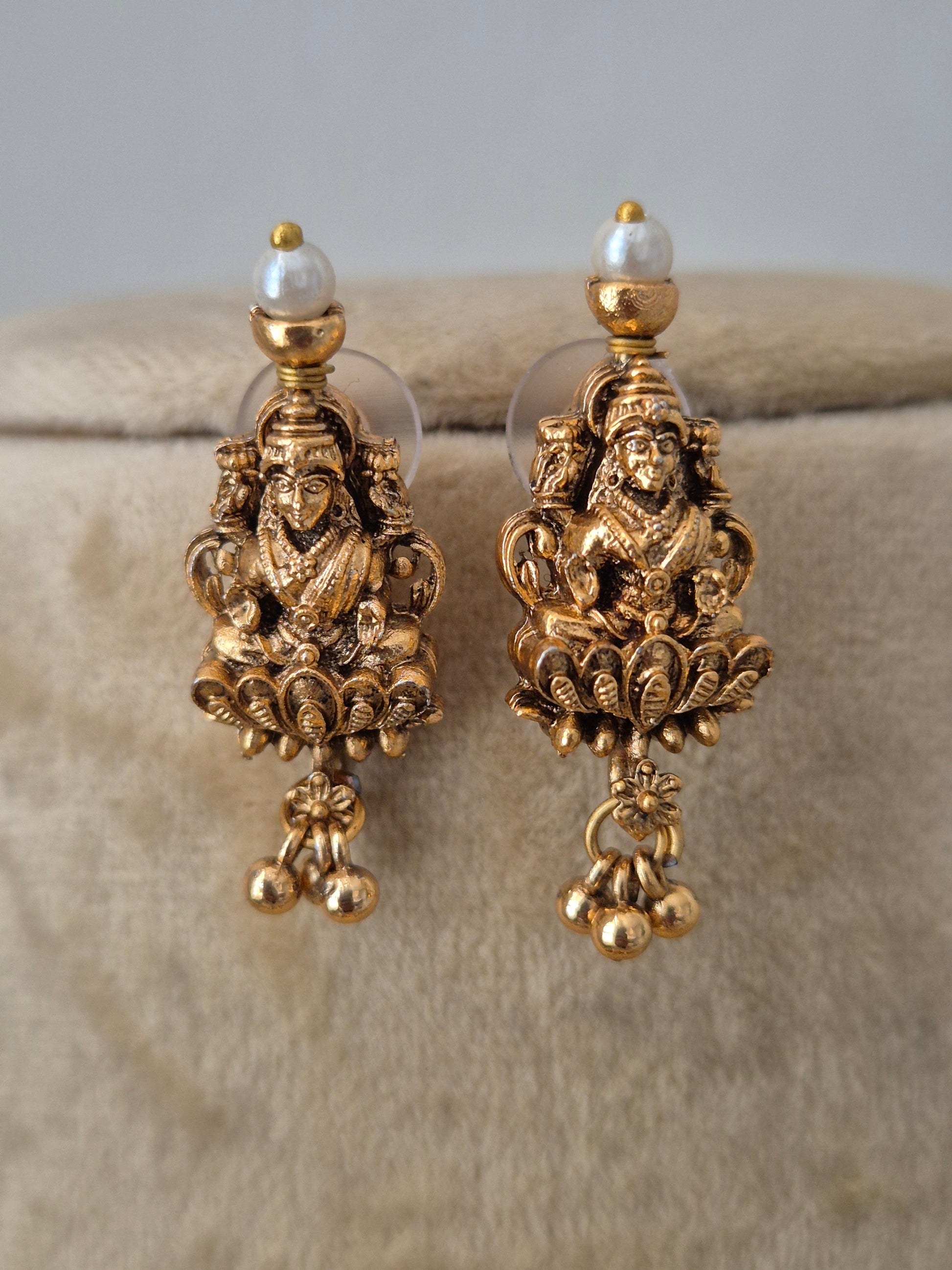A pair of ornate gold-toned dangle earrings with intricate filigree detailing and small pearl-like beads, by naitri.in