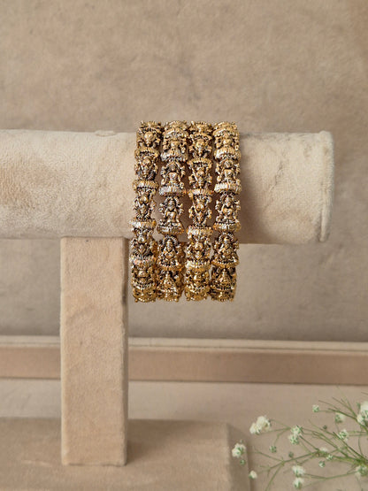 A wide gold cuff bracelet with intricate floral and scrollwork patterns, by naitri.in
