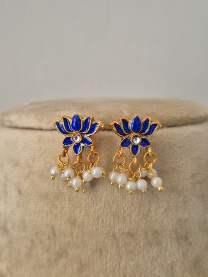 A pair of gold-plated earrings with blue enamel lotus flowers, small white pearl centers, and dangling pearl chains, by naitri.in