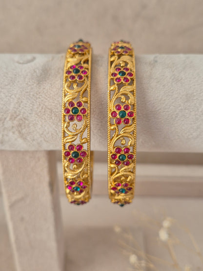 Set of two ruby and emerald stone-studded gold-plated bangles by naitri.in