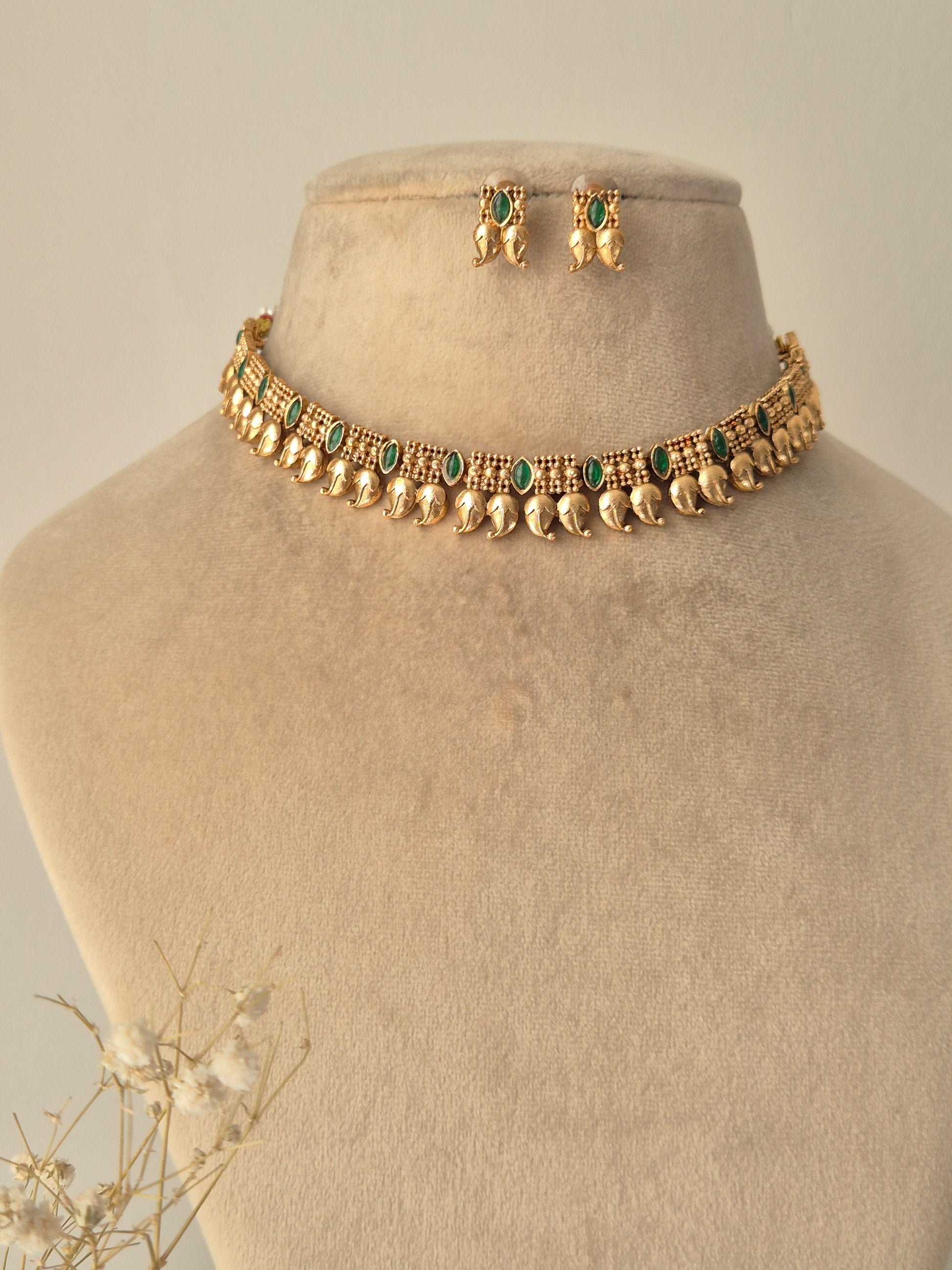 minimal Gold necklace leaf designed and Gold earrings with green stones leaf designed with small gold beads design by naitri.in 