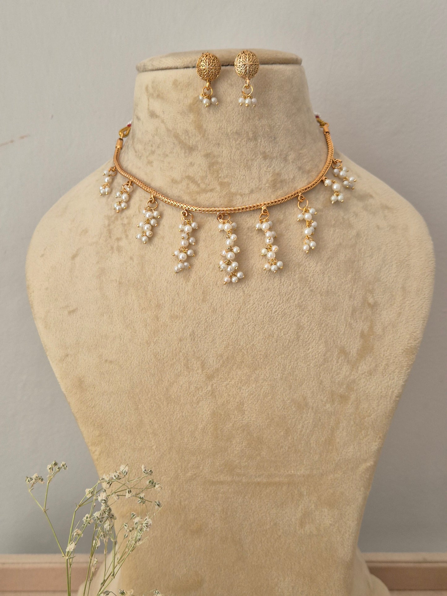 Gold-toned necklace and matching drop earrings the necklace features a delicate chain with multiple dangling pearl clusters, and the matching earrings by naitri.in