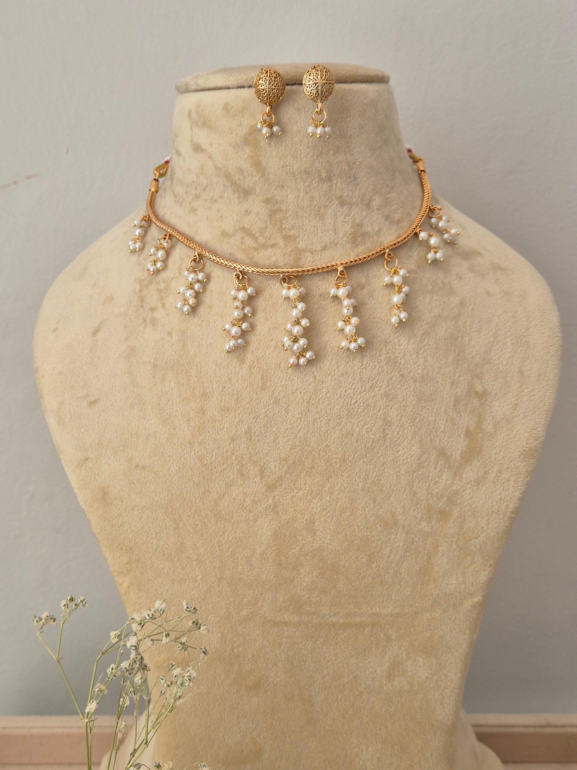 Gold-toned necklace and matching drop earrings the necklace features a delicate chain with multiple dangling pearl clusters, and the matching earrings by naitri.in