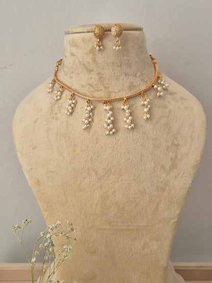 Gold-toned necklace and matching drop earrings the necklace features a delicate chain with multiple dangling pearl clusters, and the matching earrings by naitri.in