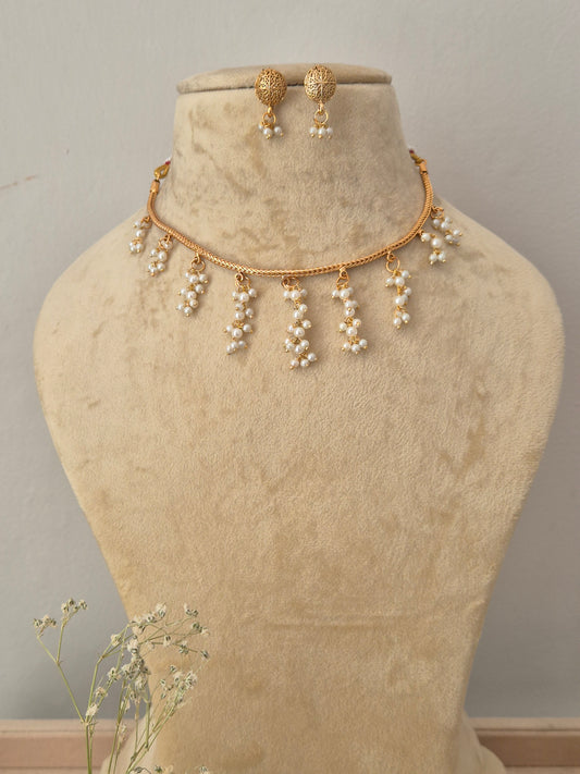 Gold-toned necklace and matching drop earrings the necklace features a delicate chain with multiple dangling pearl clusters, and the matching earrings by naitri.in