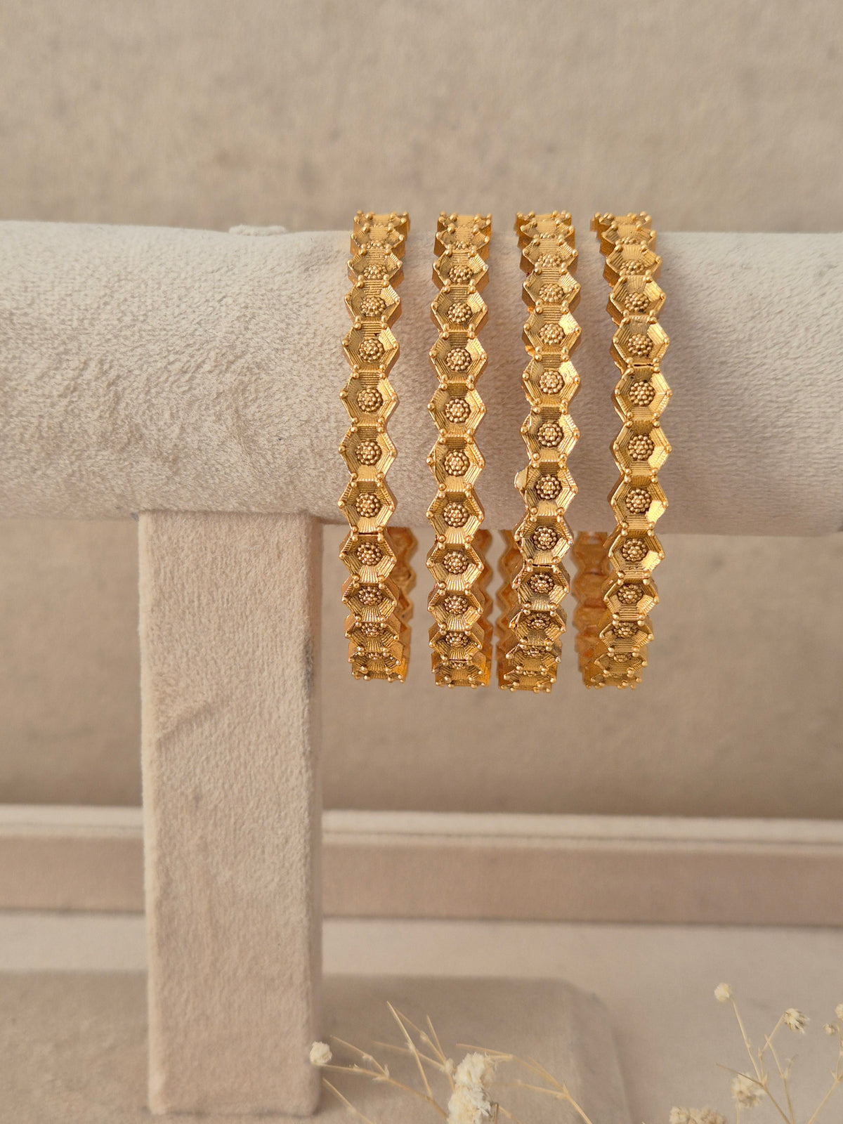 Set of 4 gold-plated bangles featuring an intricate hexagonal grid design and patterned edges by naitri.ijn