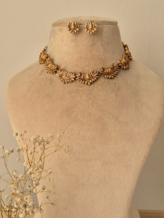 Handcrafted golden brass alloy necklace with traditional floral motifs and matching stud earrings, By naitri.in