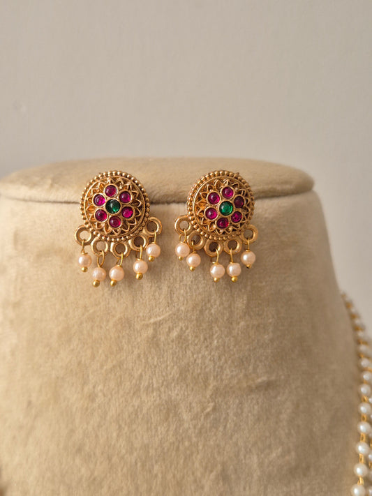 Gold earrings with gemstonesT raditional gold-plated pearl necklace with pink and green stone accents and matching earrings by naitri.in