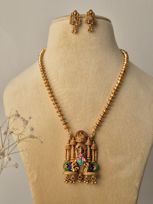  featuring a handcrafted golden temple jewellery pendant with Goddess motifs, green and pink accents, and matching drop earrings by naitri.in