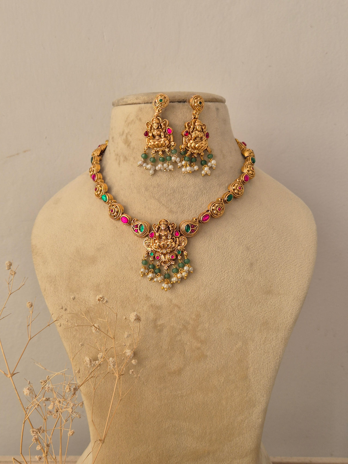 Devi Necklace Set with matching temple-style earrings featuring ruby, emerald, and pearl embellishments by Naitri.in