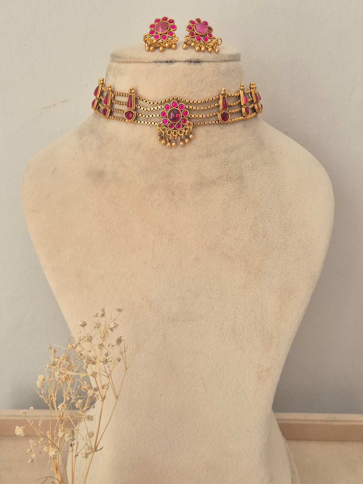 Gold-plated ethnic choker necklace featuring pink gemstone accents and matching hanging stud earrings, by naitri.in