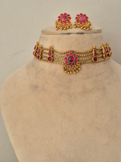 Handcrafted antique gold statement jewelry set decorated with intricate traditional patterns and pink gemstone details, ideal for festive or wedding wear by naitri.in