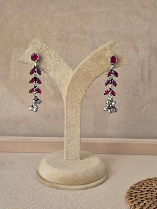Pair of handcrafted silver-plated dangle earrings with ruby-red stones by naitri.in