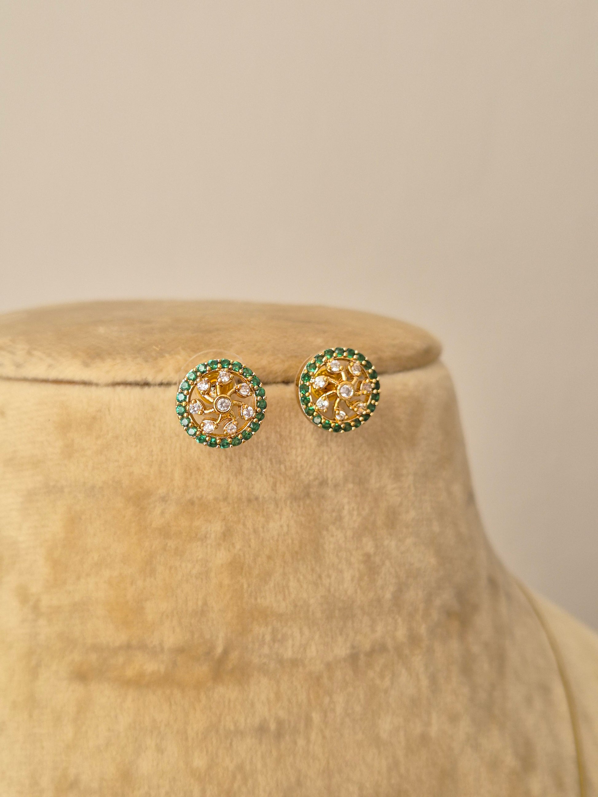 A delicate gold-toned invisible chain necklace featuring a round floral-inspired pendant with American diamonds and green beads, paired with matching round studs by naitri.in