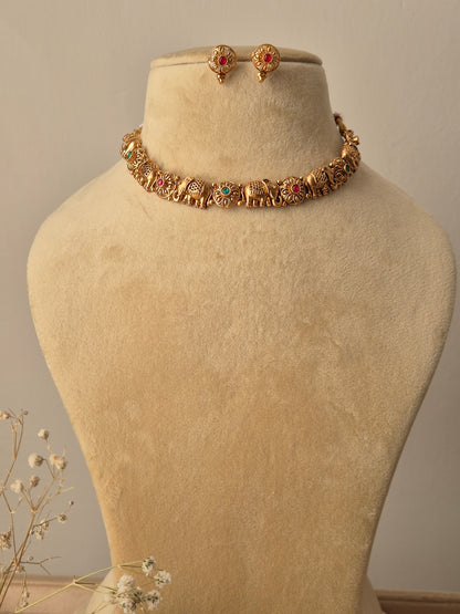 Gold bracelet with green-red gemstones elephant motifs traditional animal-themed Indian jewelry by naitri.in