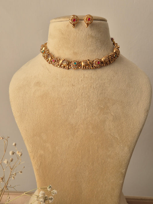 Gold bracelet with green-red gemstones elephant motifs traditional animal-themed Indian jewelry by naitri.in