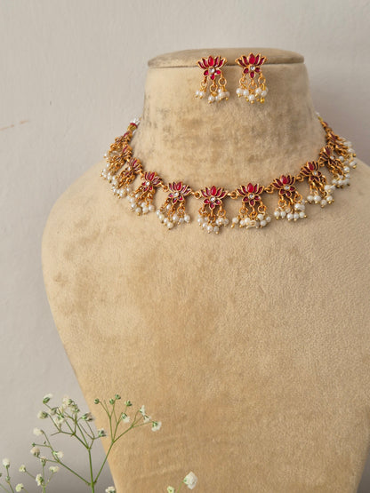 Handcrafted antique gold statement jewelry set showcasing pink stone embellishments and tiny hanging seed pearls, ideal for festive and bridal styling by naitri.in