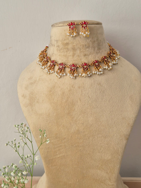 Antique gold choker necklace with pink lotus motifs and hanging pearl clusters, with matching earrings by naitri.in