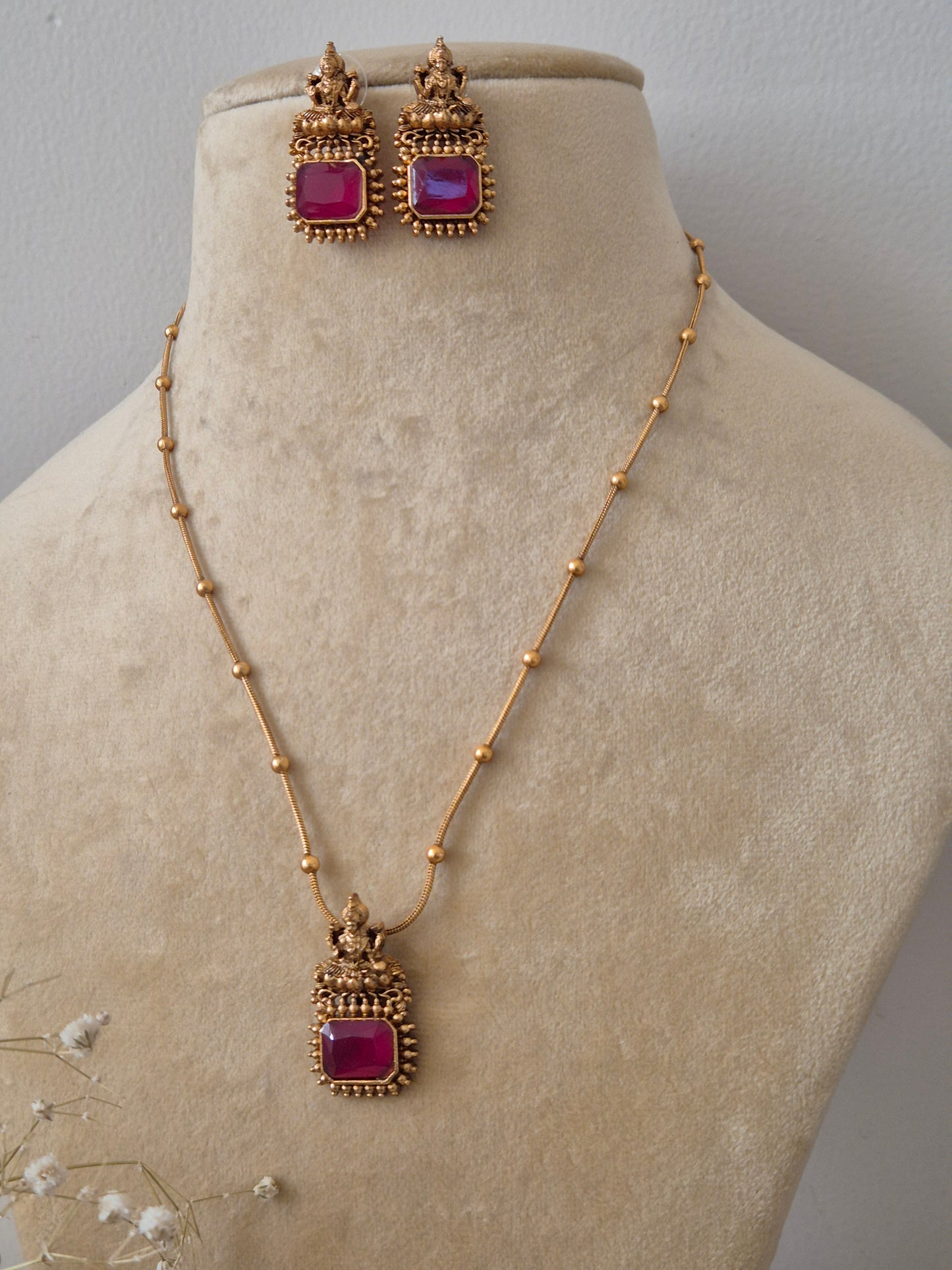 Dolly Necklace Set featuring a minimalist gold chain with a square ruby red gemstone pendant and matching emerald-red stud earrings by naitri.in