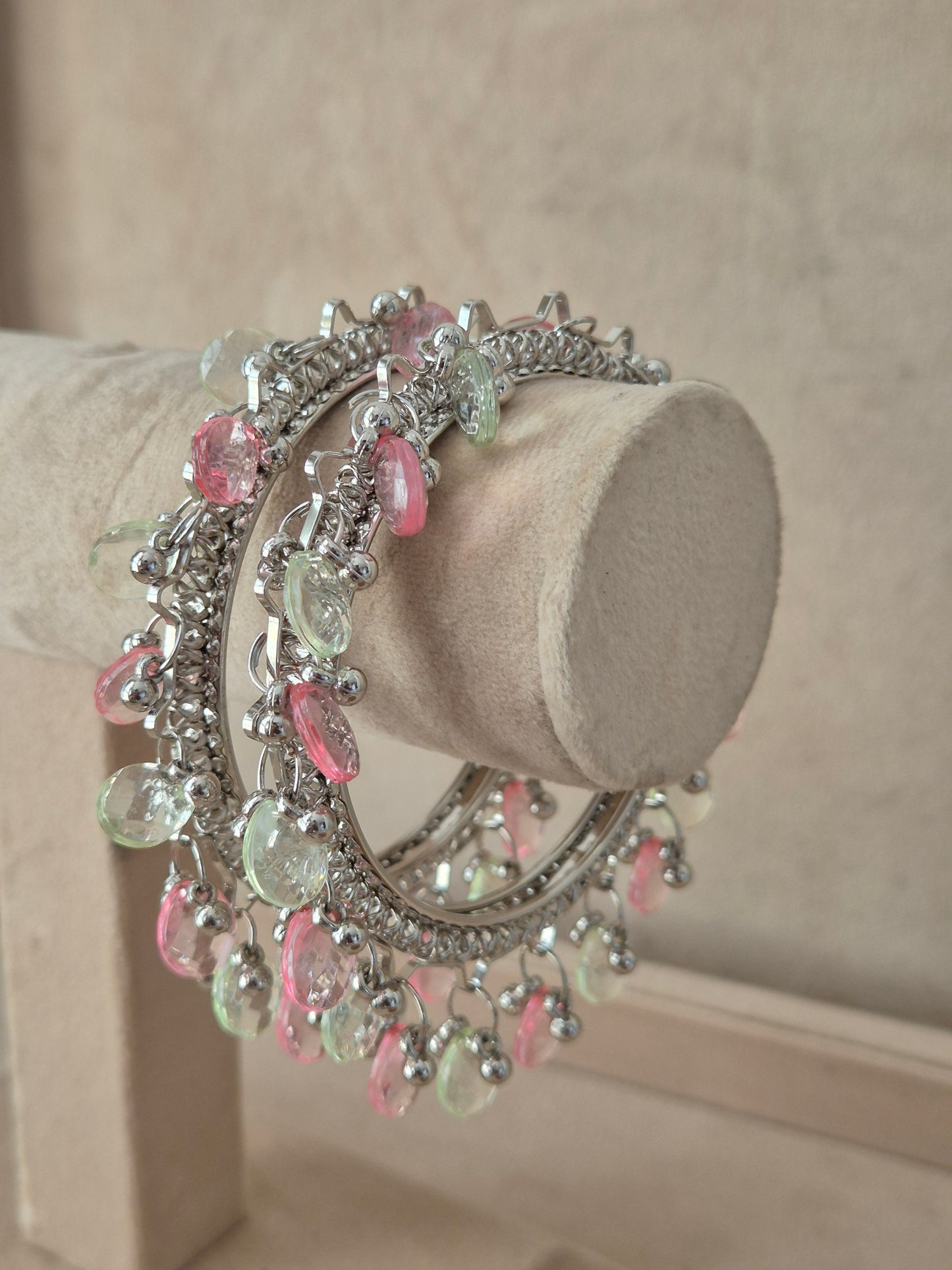 Set of 2 oxidized silver Eartha bangles with dangling pink and green pastel gemstones. Elegant antique silver ethnic bracelets with colorful festive charm details, by naitri.in