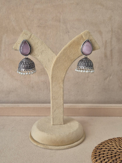 Pair of Ekta handcrafted silver-toned drop earrings with pink accents by naitri.in